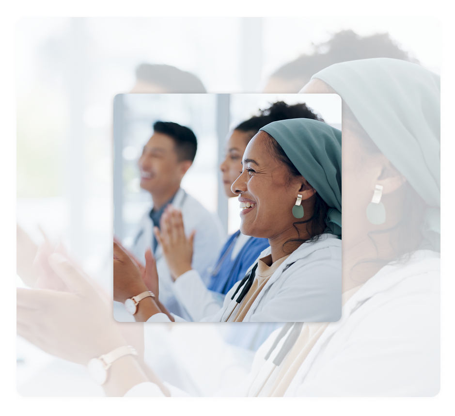 Three smiling healthcare workers clapping together with a woman in a green headwrap in the foreground, on a purple-to-teal gradient